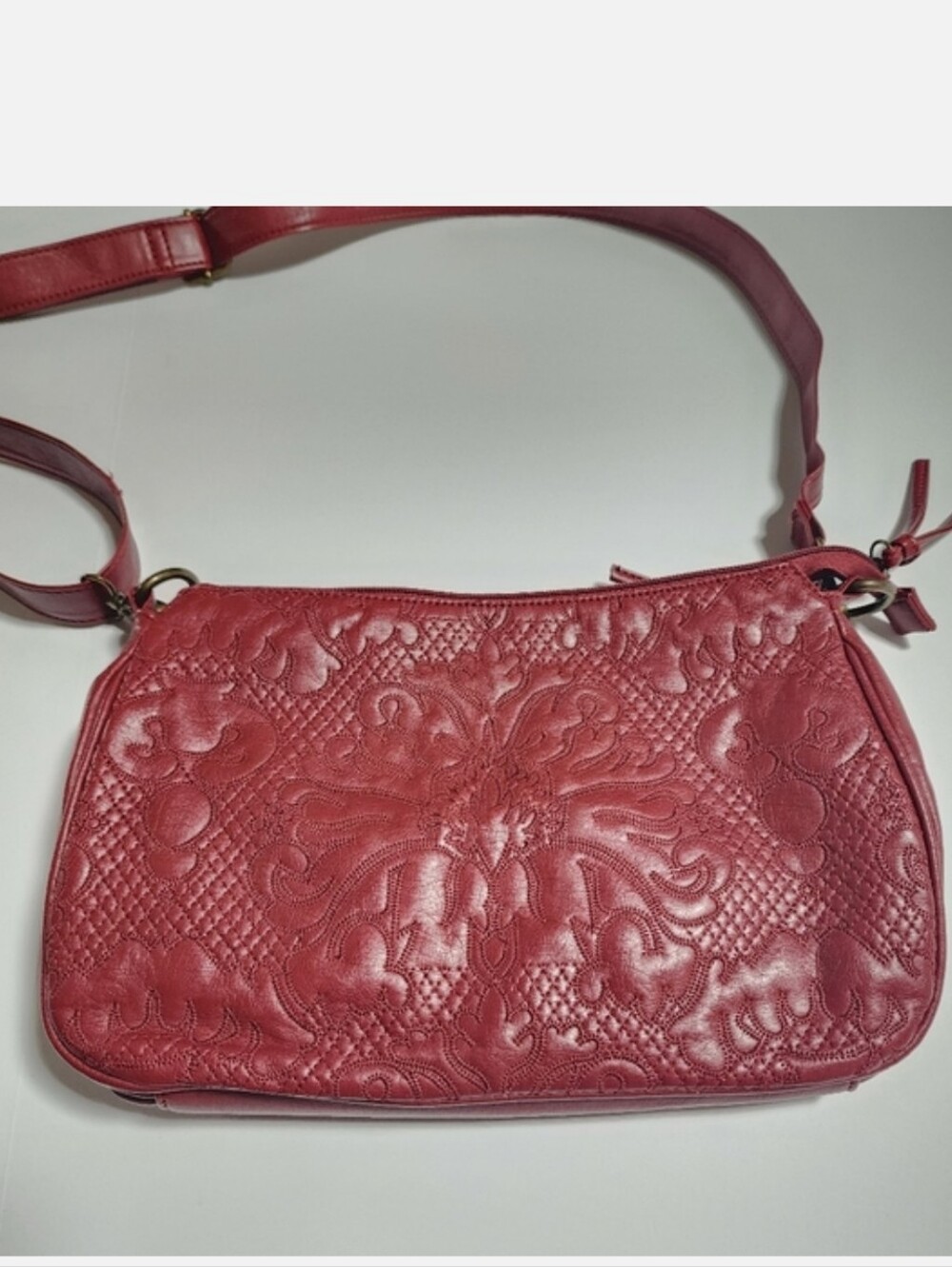 Red leather crossbody bag with embroidery detail on the front